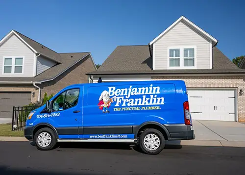 Benjamin Franklin Plumbing service truck parked in front of a residential home, ready for a plumbing service call.